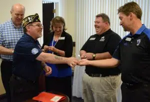 Christopher Benigno, chairman of American Legion Illinois Premier Boys State, gave EIU staff members an Illinois Premiere Boys State lapel pin after signing a 10-year contract extension. Shown, from left to right, are Mark Hudson; Lynette Drake, interim vice president for students affairs; Matt Boyer, assistant director, Residential Life and Conference Services; and Jody Stone, senior associate director, University Housing and Dining Services.