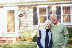 Senior couple in front of their home