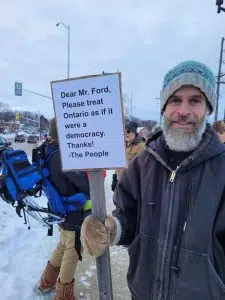 protester Ben Caesar holds a sign