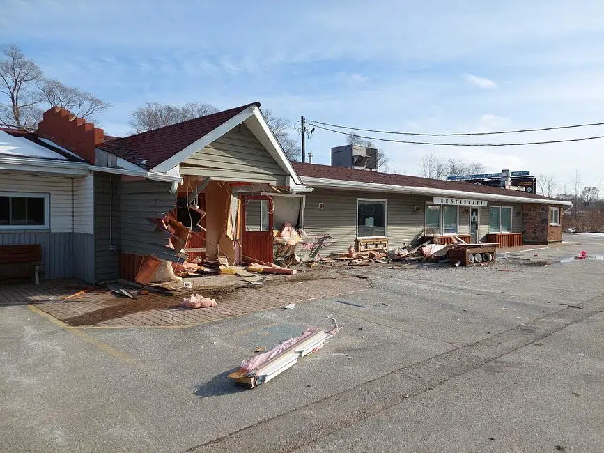 a further away shot of significant damage to a portion of the hotel, that looks like a vehicle drove into it. 