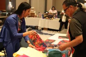 A vendor showing her merchandise at the OKIMAW Marketplace (Photo Credits -Daniel Barker-Tremblay)