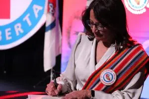 MNA President Andrea Sandmaier signing the oath to office at the Otipemisiwak Métis Government Swearing-in Ceremony