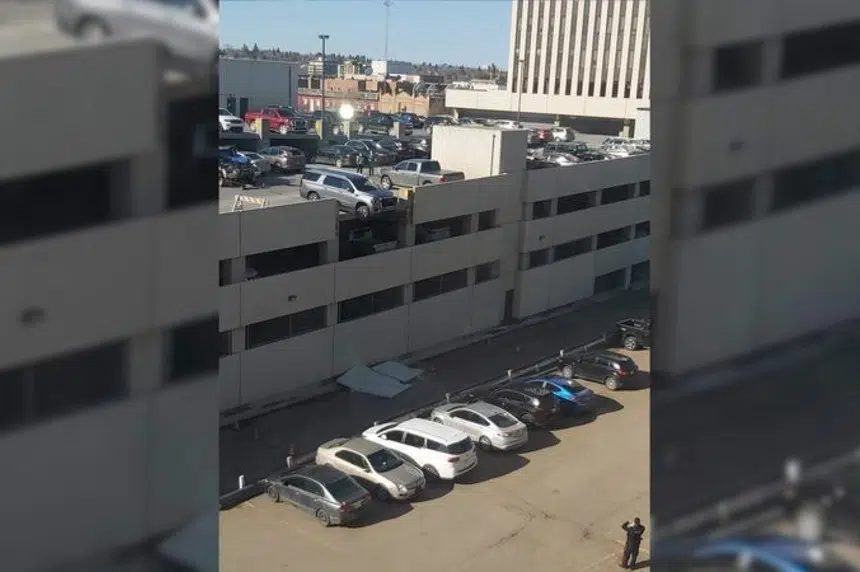 Vehicle goes through wall of top level of parking garage
